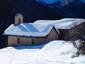 Snow covered houses by buildings against mountain