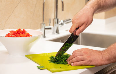 Cropped hand of person preparing food on table