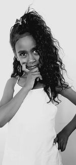 Portrait of a smiling young woman standing against white background