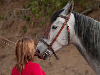 Young woman standing by horse at farm