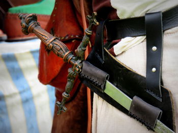 Midsection of person with sword during medieval fair