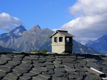 Chimney on rooftop against mountains
