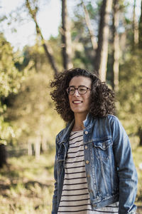 Portrait of young woman standing in forest