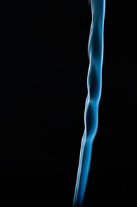 Low section of person standing against black background