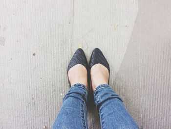 Low section of woman standing on footpath