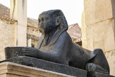 Close-up of statue against buildings