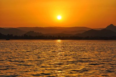 Scenic view of lake and mountains during sunset