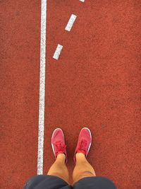 Low section of man standing on running track