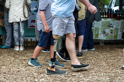 Low section of people walking on field