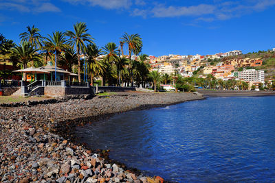 River with built structures against blue sky