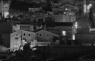 High angle view of illuminated street amidst buildings at night