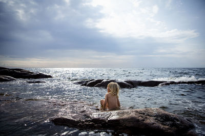 Rear view oof child sitting at sea