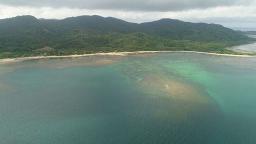 Scenic view of sea and mountains against sky