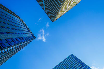 Low angle view of modern buildings against blue sky