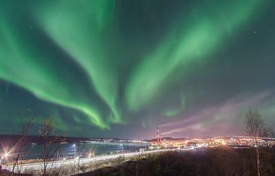 Panoramic view of illuminated lights against sky at night