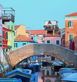 Old bridge in bricks in burano island near venice in italy and more colored houses