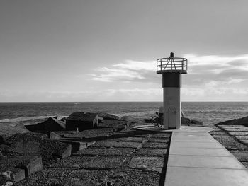 View of lighthouse on beach against sky