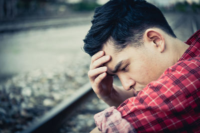 Close-up of man with headache sitting outdoors