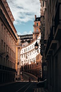 Road amidst buildings in city against sky