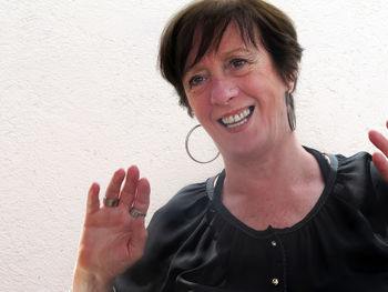 Portrait of a smiling young woman against wall