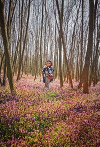 Woman on flowering plants against trees