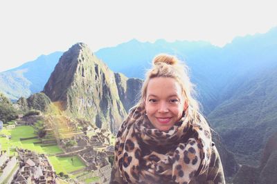 Portrait of smiling woman against mountains