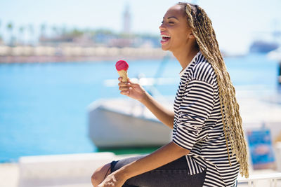 Portrait of smiling young woman drinking water in swimming pool