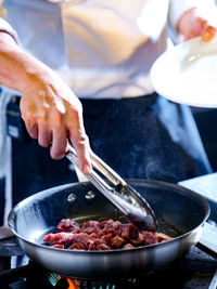 Midsection of person preparing food in kitchen