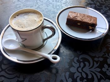 High angle view of coffee cup and chocolate cake on table