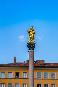 Low angle view of statue against blue sky