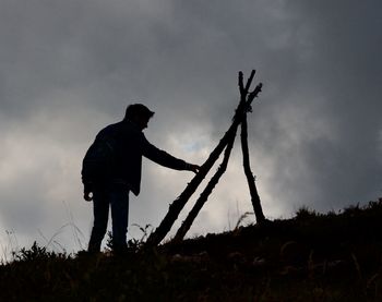 Silhouette man standing on field against sky