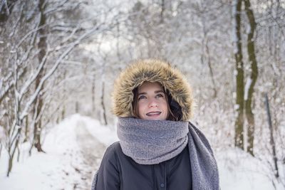 Girl standing in forest during winter