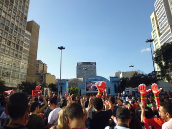 Crowd in city against clear sky