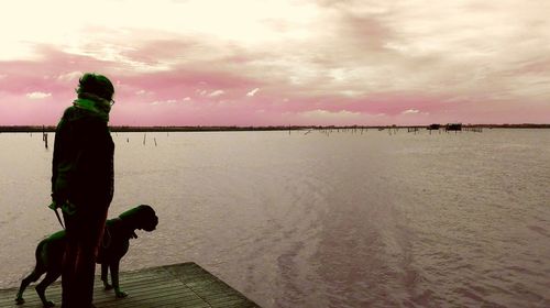 Man standing on beach against sky during sunset