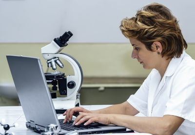 Scientist using laptop at laboratory