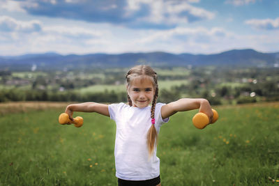 Portrait of girl standing on field