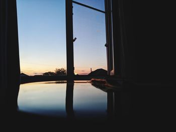 Reflection of silhouette man on window at home