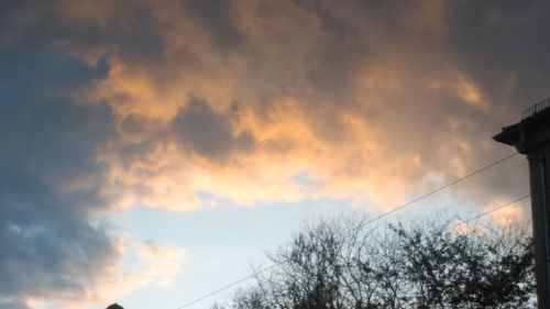 Low angle view of bare tree against cloudy sky