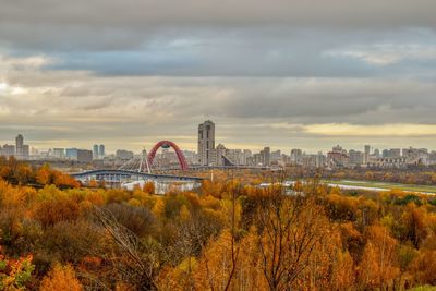 View of arch bridge and buildings against cloudy sky