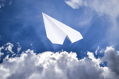 Low angle view of kites against blue sky