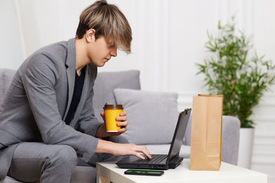 Young woman using laptop while sitting at home