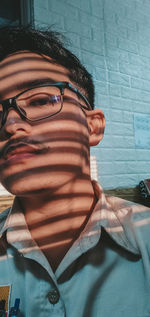 Portrait of man wearing sunglasses against wall