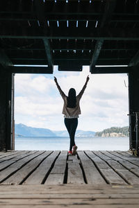 Rear view of woman standing on pier