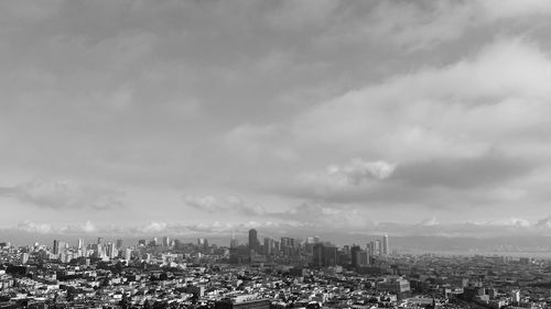 Cityscape against cloudy sky