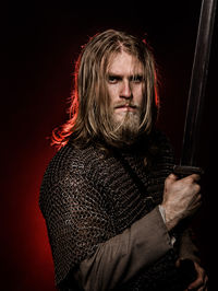 Viking holding sword against colored background