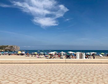 People on beach against blue sky