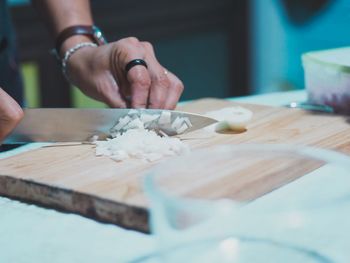 Midsection of woman preparing food on cutting board