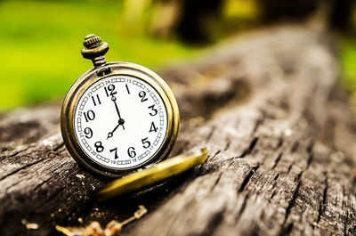 Close-up of pocket clock on wood