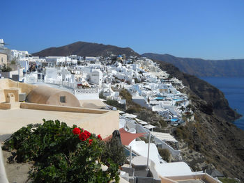 High angle view of townscape by sea against clear sky