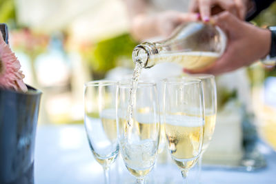 Cropped hand pouring champagne in flute